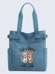 Front view of a blue canvas tote bag featuring "Life is Better with Cats" embroidery with two cute cartoon cats, an ideal gift for cat lovers.